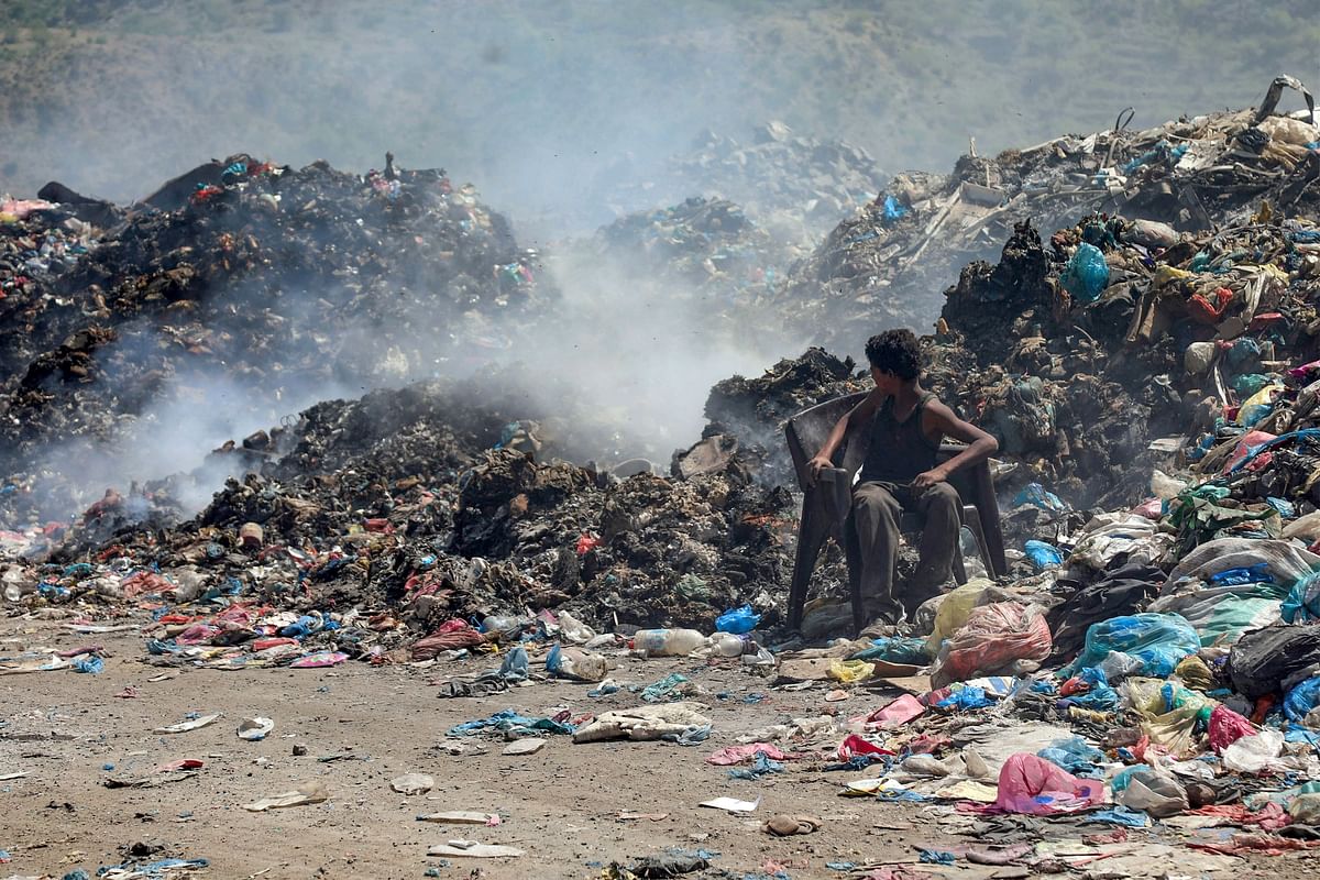 A Yemeni youth looks behind him as he sits on a chair at a garbage dump in the third-largest city Taez in southwestern Yemen, on 26 October. Photo: AFP