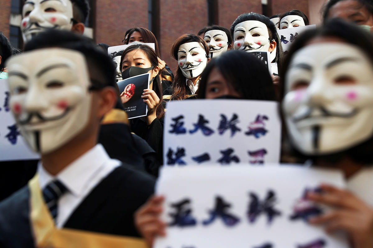 University students wearing Guy Fawkes masks pose during a news conference to support anti-government protests before their graduation ceremony at the Hong Kong Polytechnic University in Hong Kong, China, on 5 November 2019. Photo: Reuters