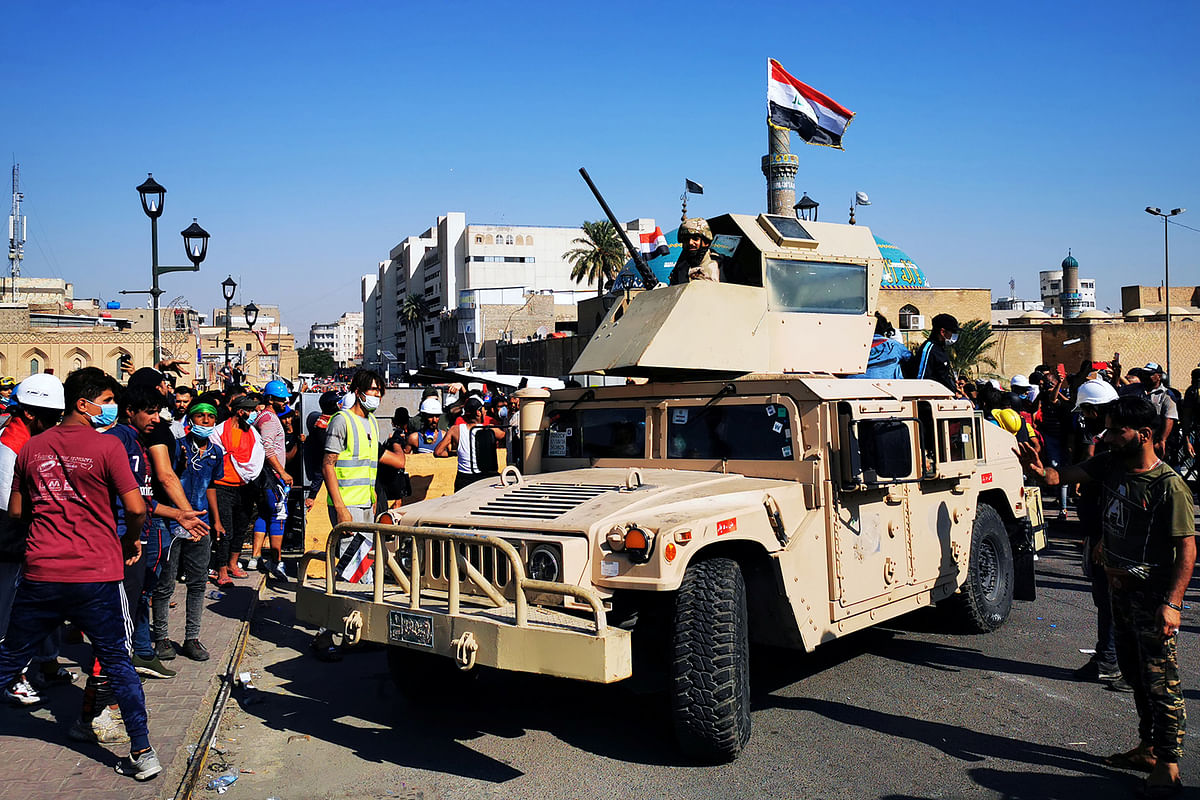An Iraqi soldier is seen on an army vehicle between the demonstrators during one of the ongoing anti-government protests in Baghdad, Iraq on 6 November 2019. Photo: Reuters