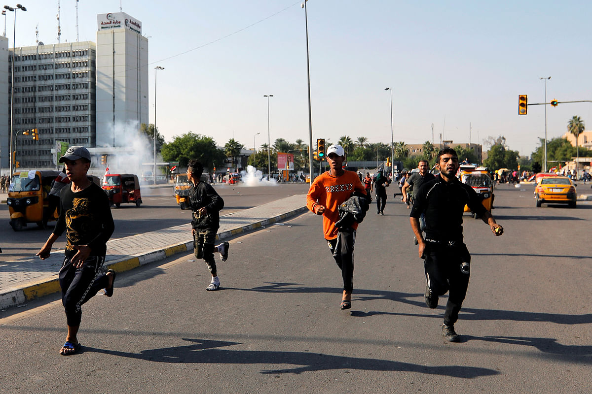 Demonstrators run after Iraqi security forces fired tear gas during the ongoing anti-government protests in Baghdad, Iraq on 6 November 2019. Reuters