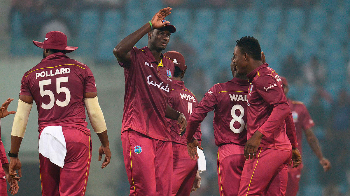West Indies` players celebrate the wicket of Afghanistan`s Gulbadin Naib (unseen) during the first one day international (ODI) cricket match between Afghanistan and West Indies at the Ekana Cricket Stadium in Lucknow on Wednesday. Photo: AFP