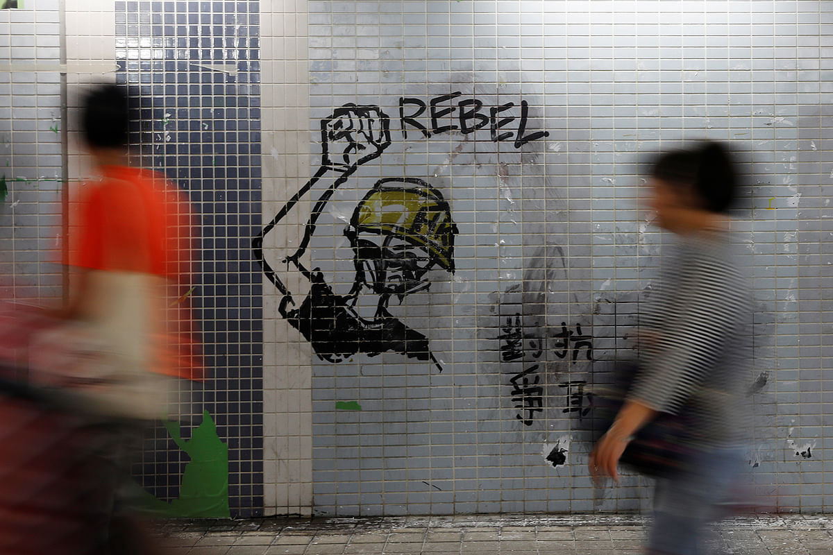 People walk by graffiti in the Kwai Chung area of Hong Kong, China, on 6 November 2019. Photo: Reuters