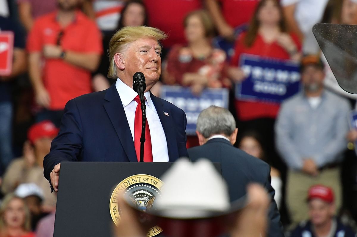A supporter (foreground) adjusts his hat as US President Donald Trump speaks during a rally at the Monroe Civic Center in Monroe, Louisiana on 6 November. Photo: AFP