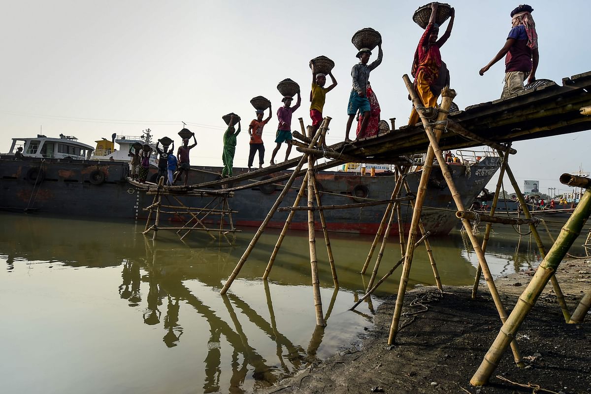 Labourers unload coal from a cargo ship in Gabtoli on the outskirts of Dhaka on 6 November 2019. Photo: AFP