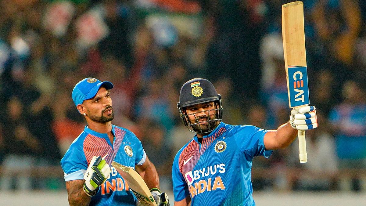India`s T20 captain Rohit Sharma (R) raises his bat after he completed his half century (50 runs) as teammate Shikhar Dhawan (L) looks on during the second T20 international cricket match of a three-match series between Bangladesh and India at Saurashtra Cricket Association Stadium in Rajkot on November 7, 2019. AFP