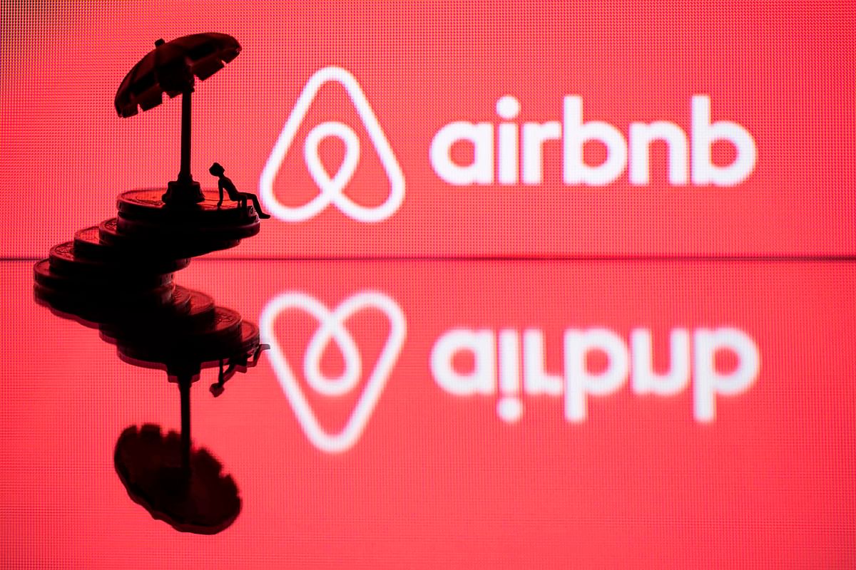 In this file photo illustration taken on 29 August 2018 in Paris on 29 August 2018, a toy umbella and a figurine on coins sre seen next to the logo of rental website Airbnb. Photo: AFP