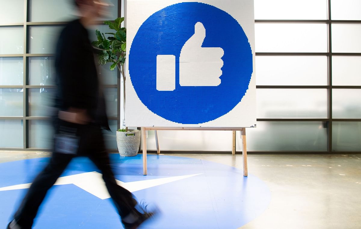 In this file photo taken on 23 October 2019 a Facebook employee walks by a sign displaying the `like` sign at Facebook`s corporate headquarters campus in Menlo Park, California. Photo: AFP