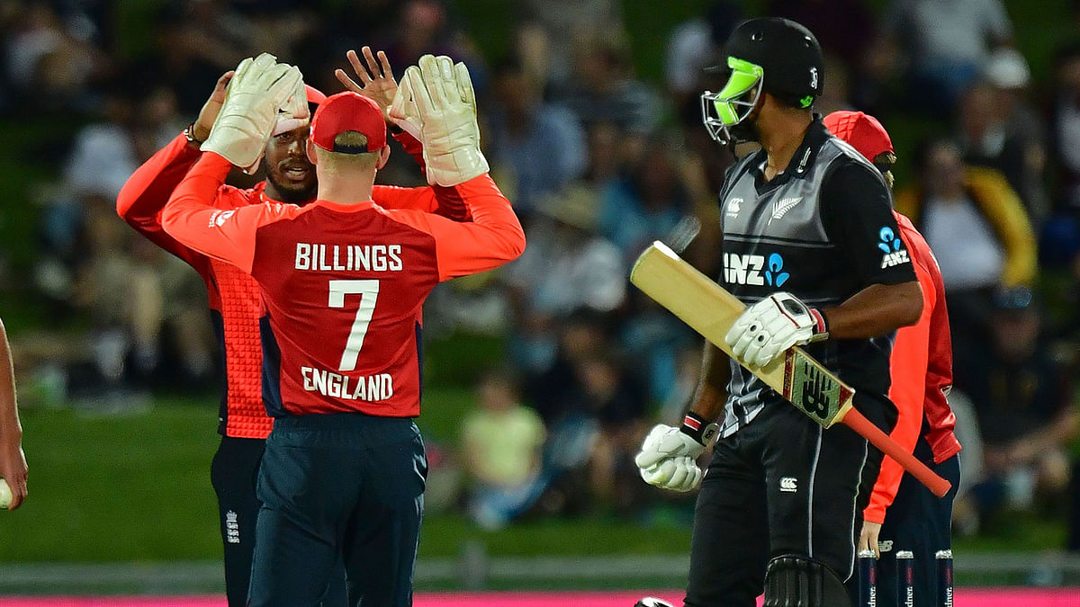 New Zealand`s Ish Sodhi (R) walks from the field after being run out as England`s wicketkeeper Sam Billings (front L) celebrates with teammate Chris Jordan during the Twenty20 cricket match between New Zealand and England at McLean Park in Napier on 8 November 2019. Photo: AFP