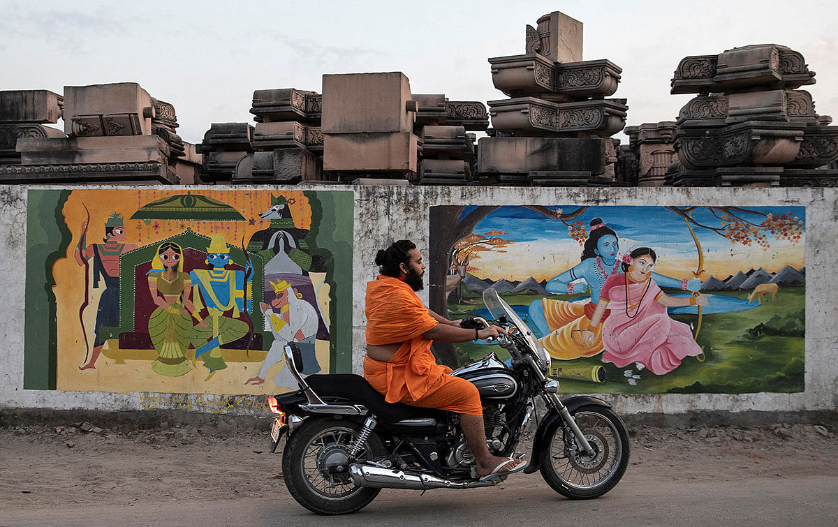 A Hindu priest rides past a workshop where the pillars that Hindu nationalist group Vishva Hindu Parishad (VHP) say will be used to build a Ram temple at the disputed religious site are kept, in Ayodhya, India, on 22 October 2019. Photo: Reuters
