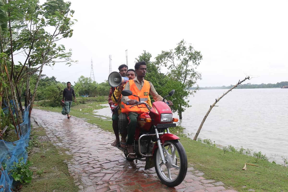 Persons on a motorcycle use a microphone to announce on the ensuing cyclone Bulbul asking them to go to cyclone centres at Pankhali, Dakope in Khulna on 9 November 2019. Photo: Saddam Hossain
