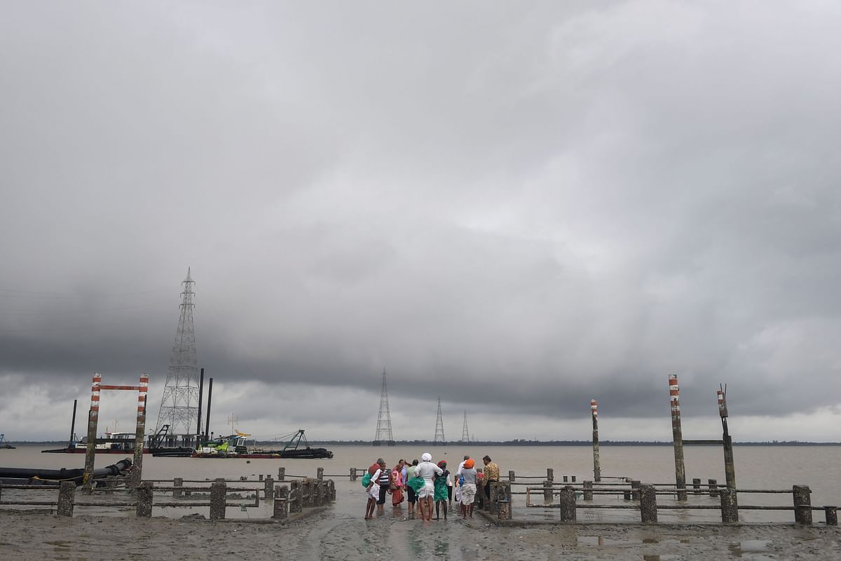 Hindu pilgrims stand by a dock after a ferry service to Sagar Island was suspended due to the approaching Cyclone Bulbul in Kakdwip in West Bengal state on 9 November 2019. Cyclone Bulbul, packing a maximum wind speed of 120 kilometres per hour (75 miles), is on course to make landfall near the Sundarbans, the world`s largest mangrove forest, which straddles Bangladesh and part of eastern India. Photo: AFP