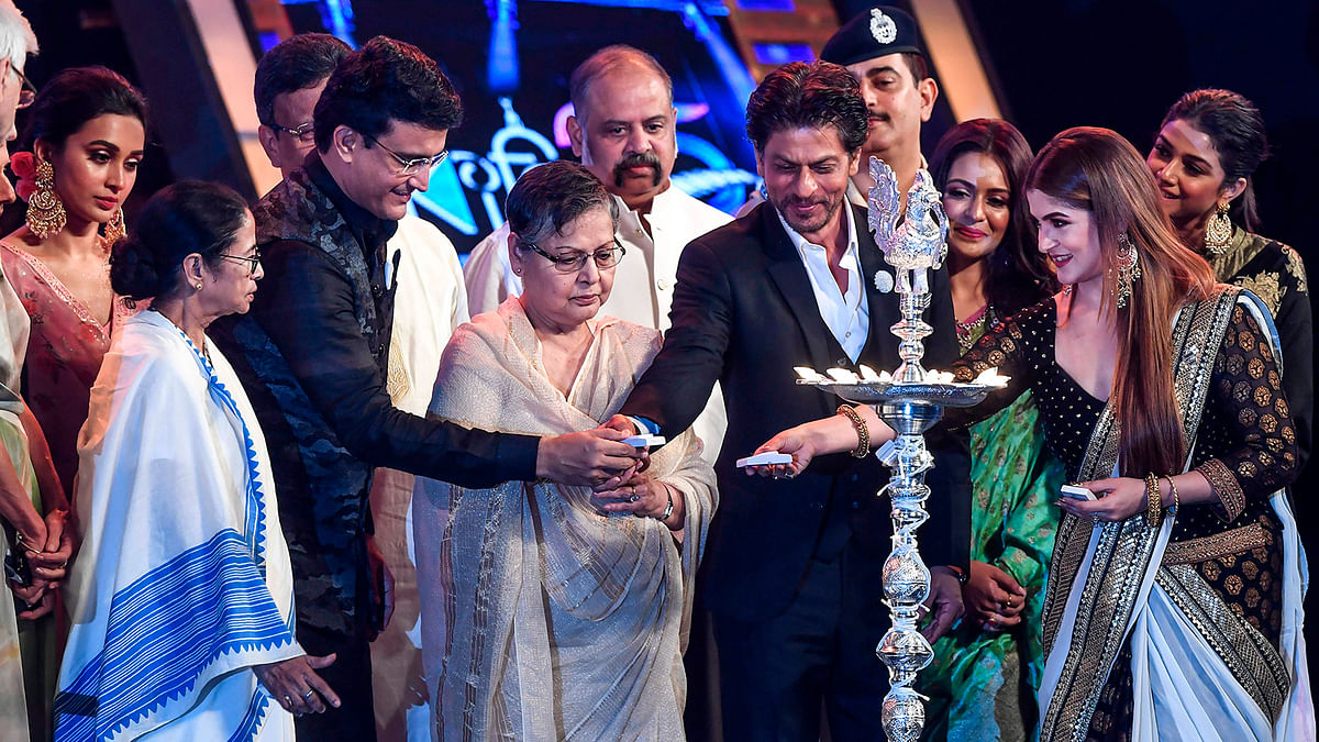 Bollywood actor Shah Rukh Khan (C-R) lights up the traditional lamp as West Bengal chief minister Mamata Banerjee (2L) looks on during the inauguration of the 25th Kolkata International Film Festival in Kolkata on 8 November, 2019. Photo: AFP