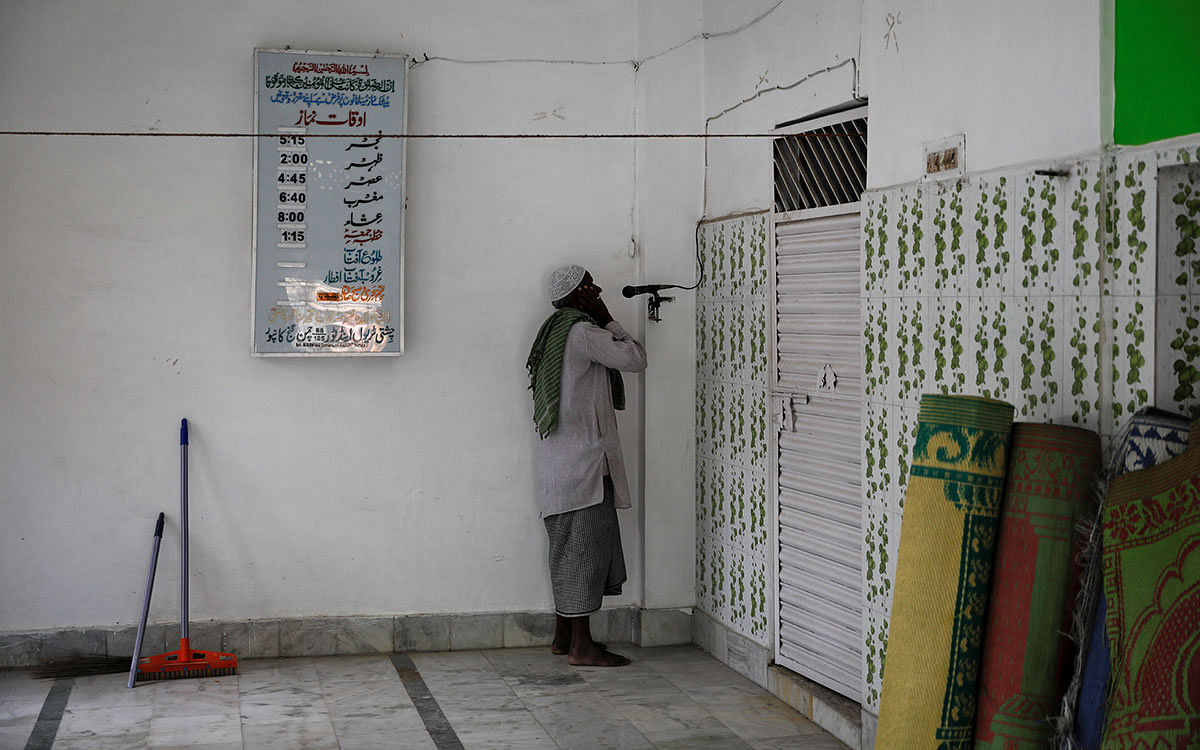 A muezzin makes his call to afternoon prayers inside a mosque in Ayodhya, India, on 22 October 2019. Photo: Reuters