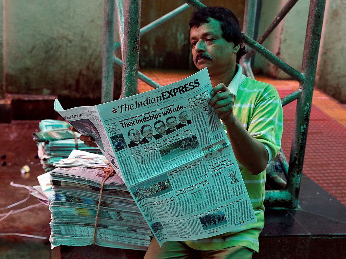 A man reads a newspaper with a headline about Supreme Court`s verdict on a disputed religious site claimed by both majority Hindus and Muslim in Ayodhya, in Kolkata, India, on 9 November 2019. Photo: Reuters