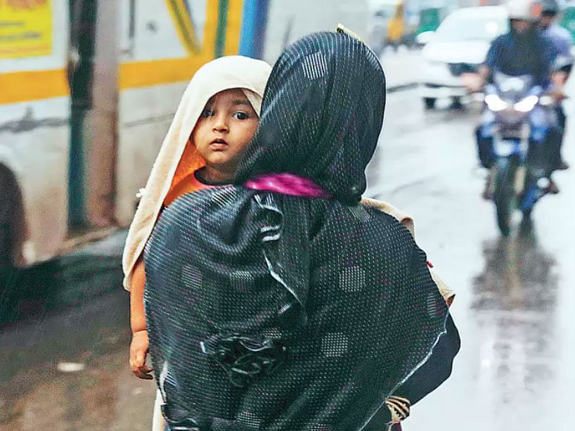 A mother walks with her child in the drizzle at Farmgate, Dhaka as cyclone Bulbul hit Bangladesh on 9 November 2019. Photo: Sabina Yesmin