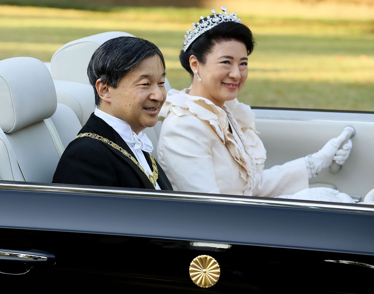 Japan’s Emperor Naruhito (L) and Empress Masako (R) wave during a royal parade in Tokyo on 10 November 2019. Photo: AFP