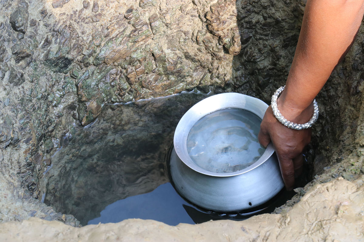 A woman collects water at Shilachhara in Khagrachhari on 7 November 2019. Photo: Nerob Chowdhury