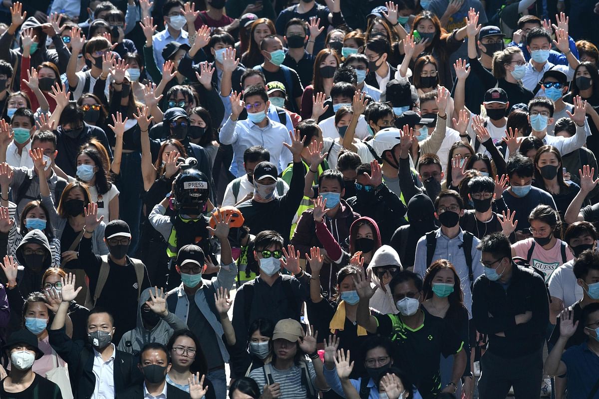 Marching protesters hold up their hands as a symbol of the five demands of the movement, during a protest in Hong Kong`s Central district on 11 November. Photo: AFP