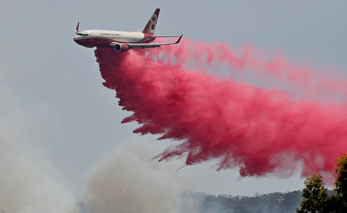 A Rural NSW Fire Service plane drops fire retardent on an out of control bushfire near Taree, 350km north of Sydney on 12 November 2019. A state of emergency was declared on 11 November 2019 and residents in the Sydney area were warned of `catastrophic` fire danger as Australia prepared for a fresh wave of deadly bushfires that have ravaged the drought-stricken east of the country. Photo: AFP