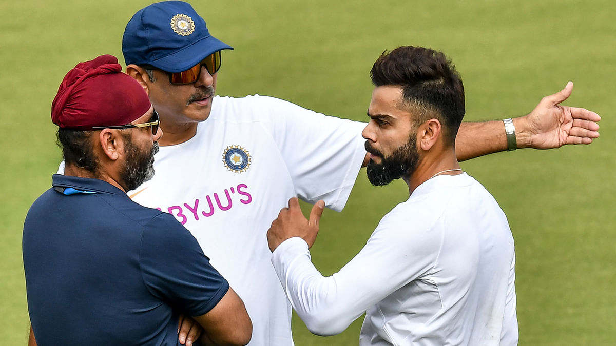 India`s cricket selector Sarandeep Singh (L), coach Ravi Shastri (C) and captain Virat Kohli discuss during a training session ahead of the first test match between India and Bangladesh at Holkar Cricket Stadium in Indore on Tuesday. Photo: AFP
