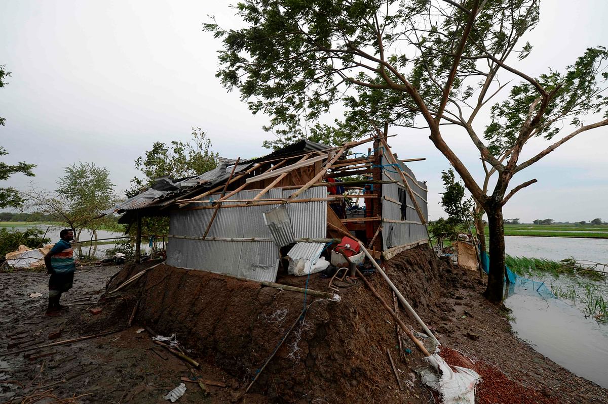 A man stands next to his damaged house after cyclone Bulbul hit the area in Koyra, some 100 km from Khulna on 10 November 2019. Photo: AFP