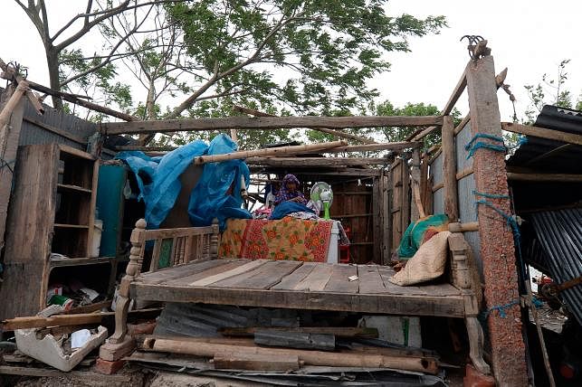 A woman gathers her belongings from a house after cyclone Bulbul hit the area in Koyra, some 100 km from Khulna on 10 December 2019. AFP File Photo