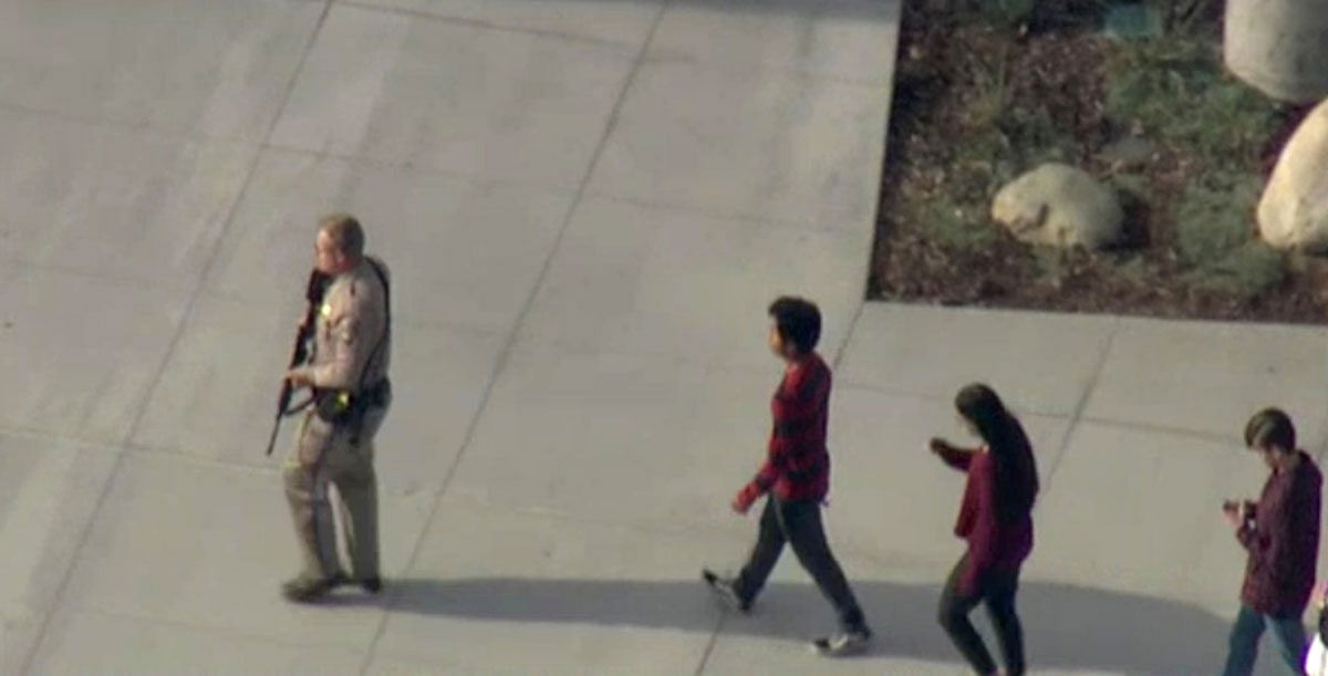 A law enforcement official leads students at the scene of a shooting at Saugus high school in Santa Clarita. Photo: Reuters