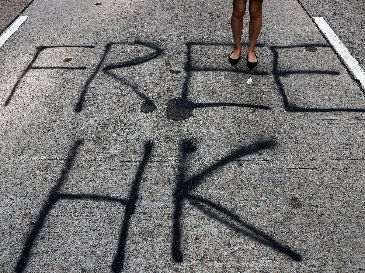 An anti-government demonstrator stands on a graffiti on a road during a protest in Central, Hong Kong, China on 14 November 2019. Photo: Reuters