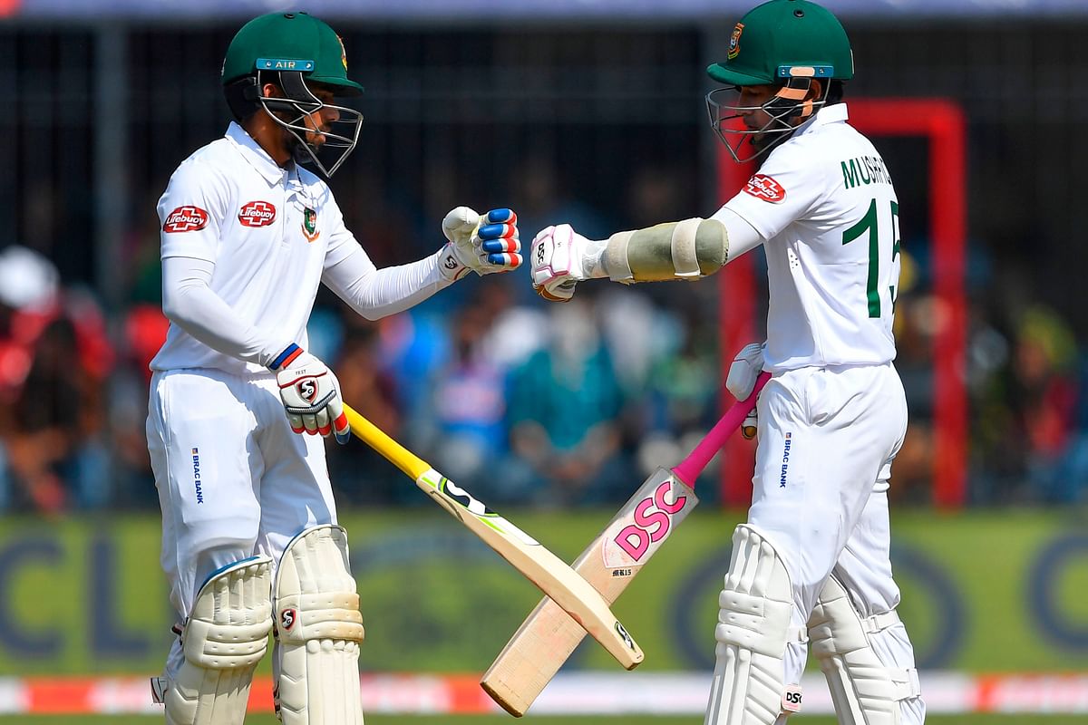 Bangladesh`s captain Mominul Haque (L) and Mushfiqur Rahim bump fists during the first day of the first Test cricket match between India and Bangladesh at the Holkar Cricket Stadium in Indore on 14 November 2019. Photo: AFP
