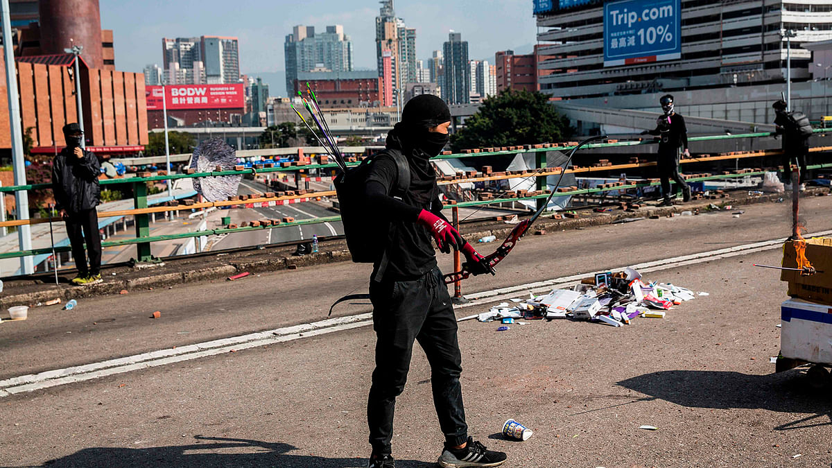 A protester with a bow and arrows stands on a barricaded street outside The Hong Kong Polytechnic University in Hong Kong on 15 November 2019. Photo: AFP