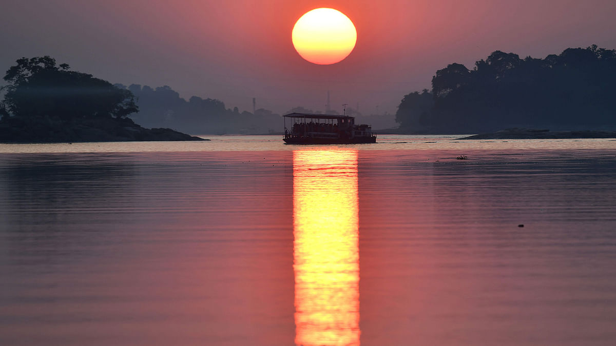 A ferry travels along the river Brahmaputra during sunset in Guwahati on 15 November 2019. Photo: AFP