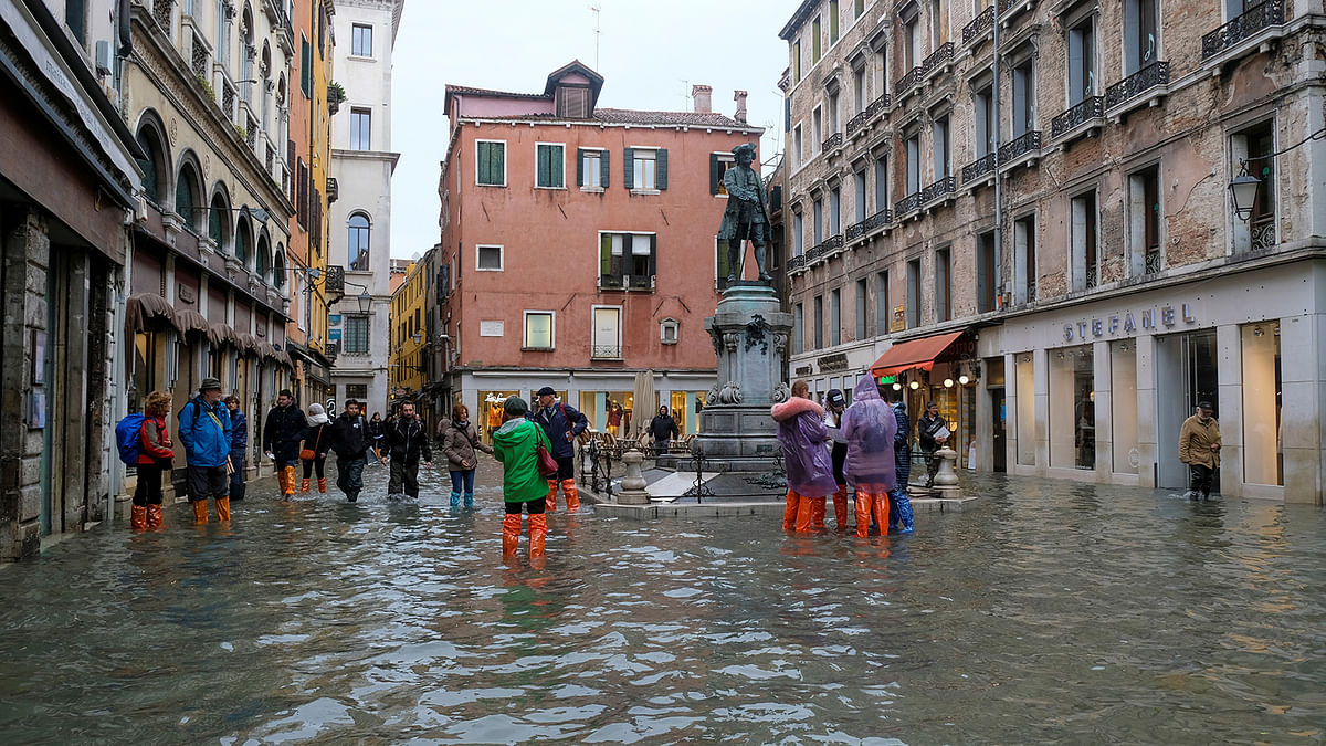 People walk in the flooded street during a period of seasonal high water in Venice, Italy, on 15 November 2019. Photo: Reuters