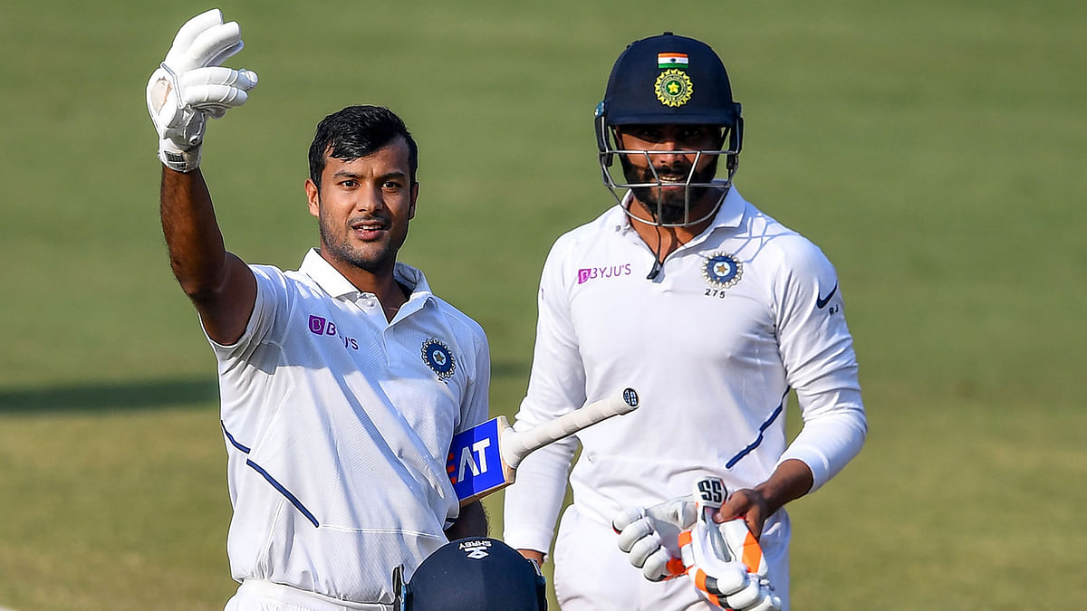 India`s Mayank Agarwal (L) flashes two fingers after scoring a double-century (200 runs) as teammate Ravindra Jadeja looks on during the second day of the first Test cricket match of a two-match series between India and Bangladesh at Holkar Cricket Stadium in Indore on 15 November 2019. Photo: AFP