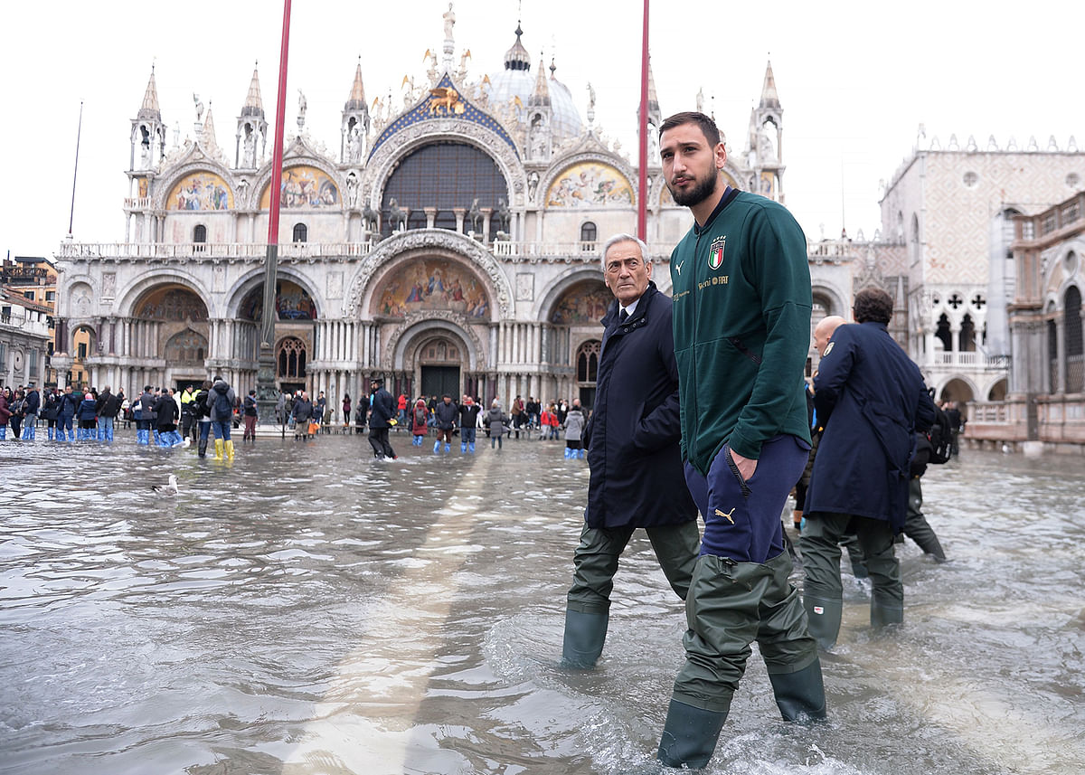 VAc Milan`s goalkeeper Gianluigi Donnarumma walks in St. Mark square on 16 November 2019 in Venice, three days after the city suffered the highest tide in 50 years. Photo: AFP