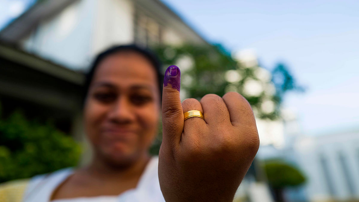 A woman shows her inked finger outside a polling station after casting her vote during the country`s presidential election in Colombo on 16 November 2019. Photo: AFP