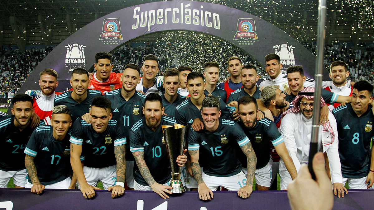 Argentina`s Lionel Messi poses with a trophy and teammates as they celebrate after the international friendly football match against Brazil at King Saud University Stadium, Riyadh, Saudi Arabia on 15 November 2019. Photo: Reuters