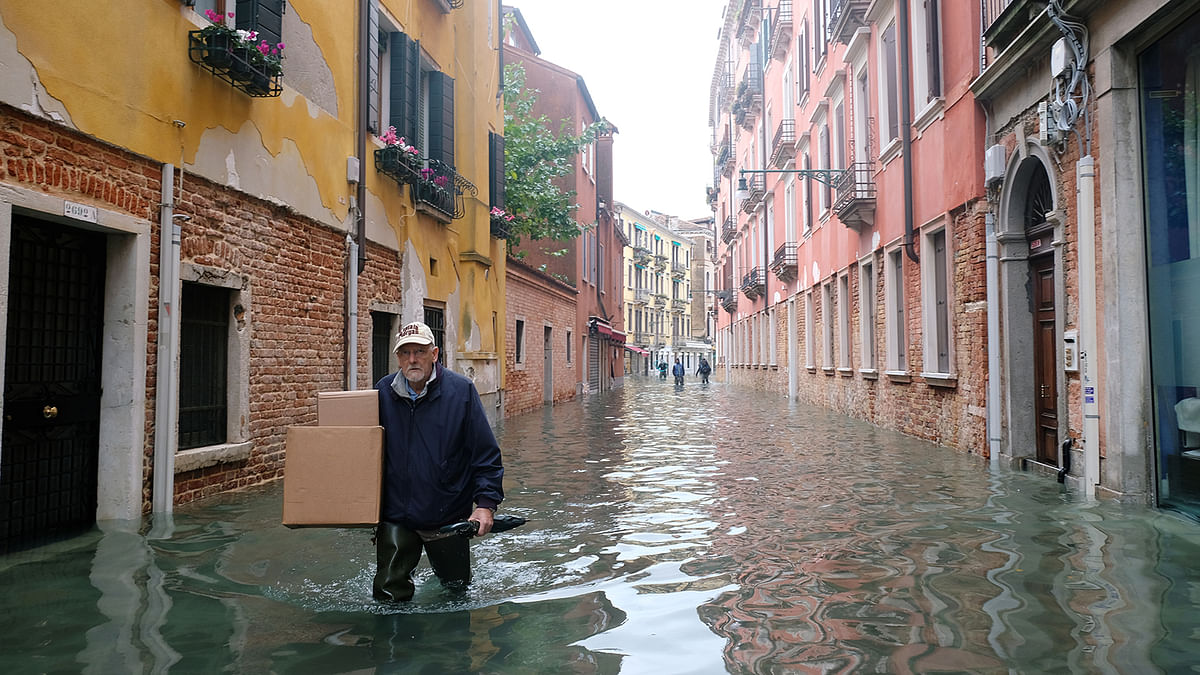 A man walks on the flooded street during a period of seasonal high water in Venice, Italy on 15 November 2019. Photo: Reuters