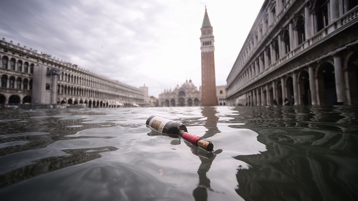 A general view shows a bottle of wine floating on the water of the flooded St. Mark`s Square, with St. Mark`s Basilica (Rear L) and the Bell Tower on 15 November 2019 in Venice, two days after the city suffered its highest tide in 50 years. Photo: AFP