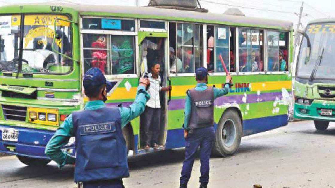 Two policemen signal a bus to follow rules. Photo: UNB