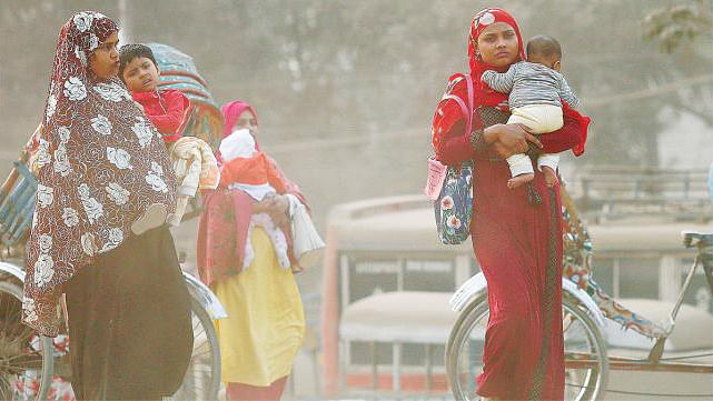 Women carrying children cross crossing a road in a cloud of dust at Postogola, Dhaka. Prothom Alo File Photo