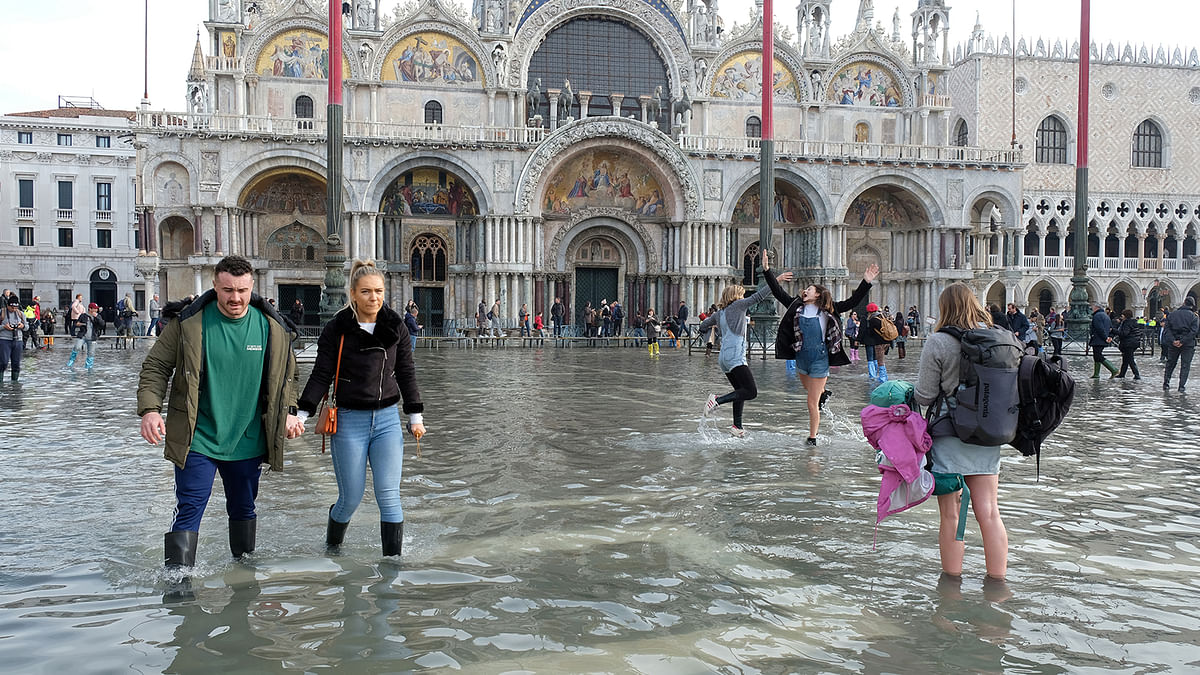 Tourists pose for photographs in St. Mark’s Square after days of severe flooding in Venice, Italy, on 16 November 2019. Photo: Reuters