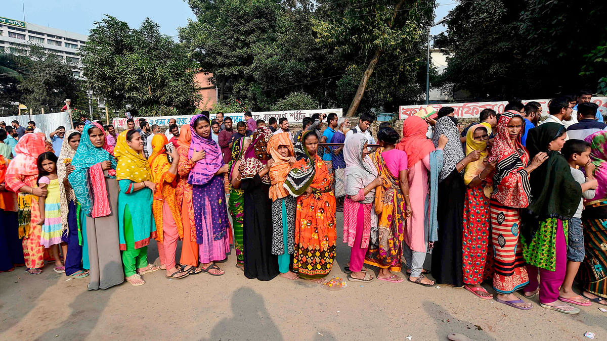 People wait in line to purchase subsidised onions in Dhaka on 17 November, 2019. Photo: AFP