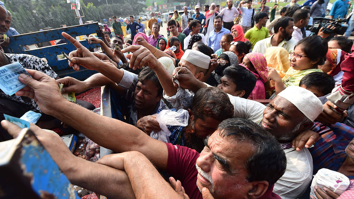 People scuffle as they purchase subsidised onions in Dhaka on 17 November, 2019. Photo: AFP