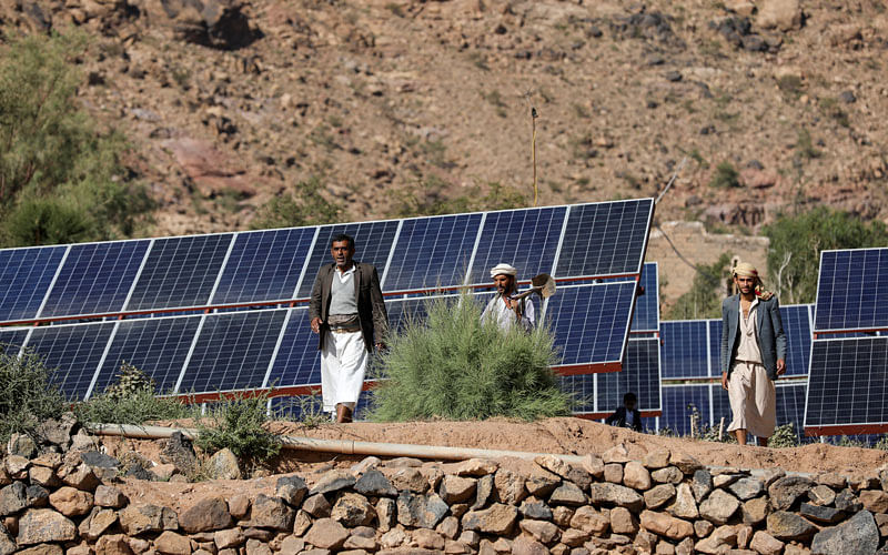 Farmers walk next to solar panels at a farmland in Wadi Dhahr near Sanaa, Yemen on 28 October. Photo: Reuters