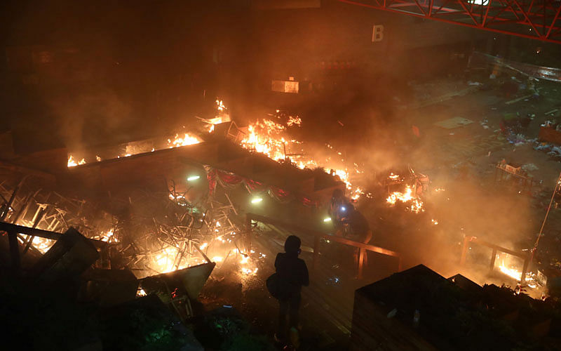 A protester looks at fire at Hong Kong Polytechnic University (PolyU) during an anti-government protest in Hong Kong, China on 18 November. Photo: Reuters