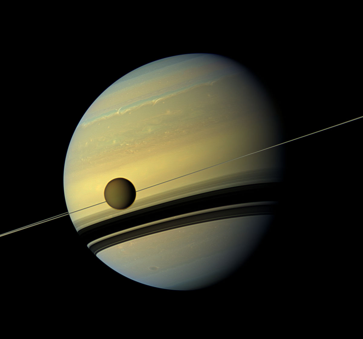 This file photo taken on 31 August 2012 shows a giant of a moon appearing before a giant of a planet undergoing seasonal changes in this natural colour view of Titan and Saturn from NASA`s Cassini spacecraft. Photo: AFP