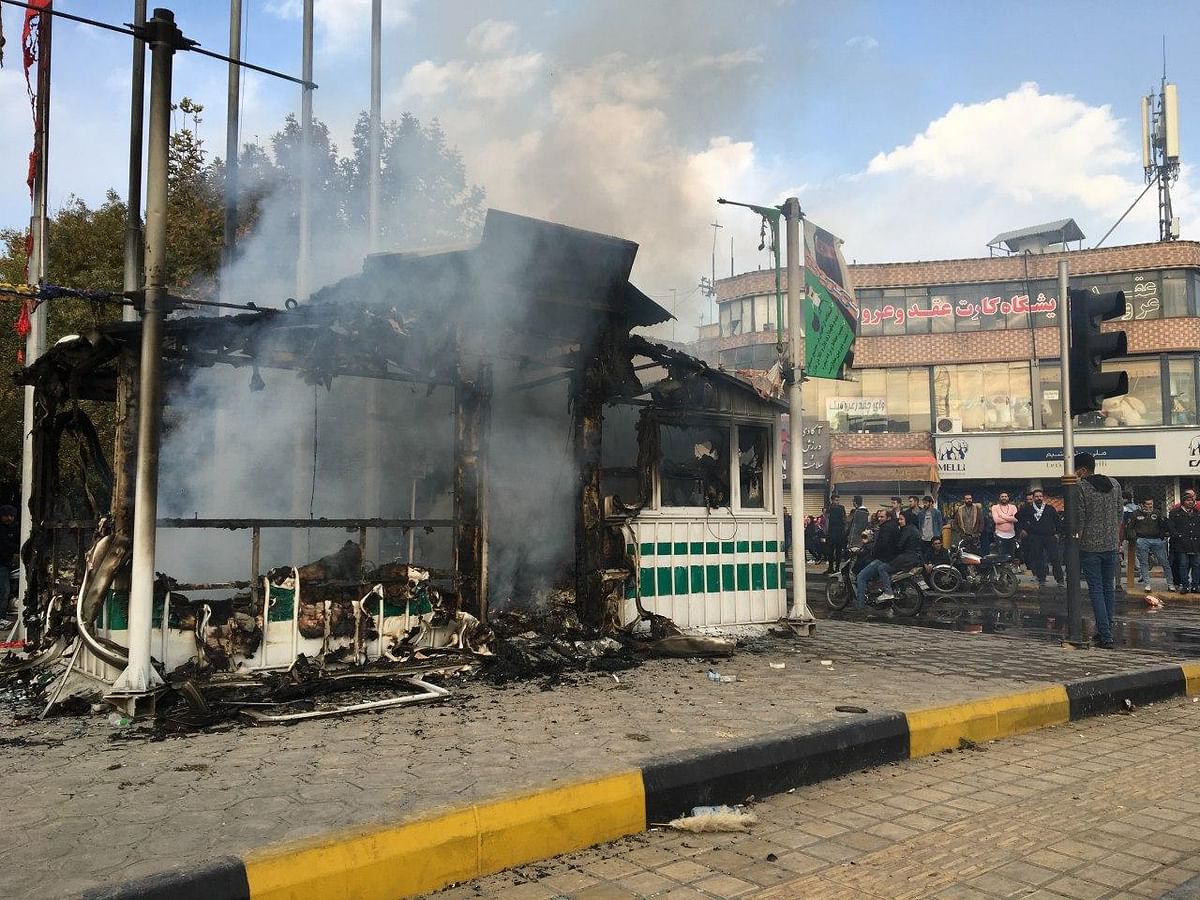 Iranians gather around a charred police station that was set ablaze by protesters during a demonstration against a rise in gasoline prices in the central city of Isfahan on 17 November. Photo: AFP