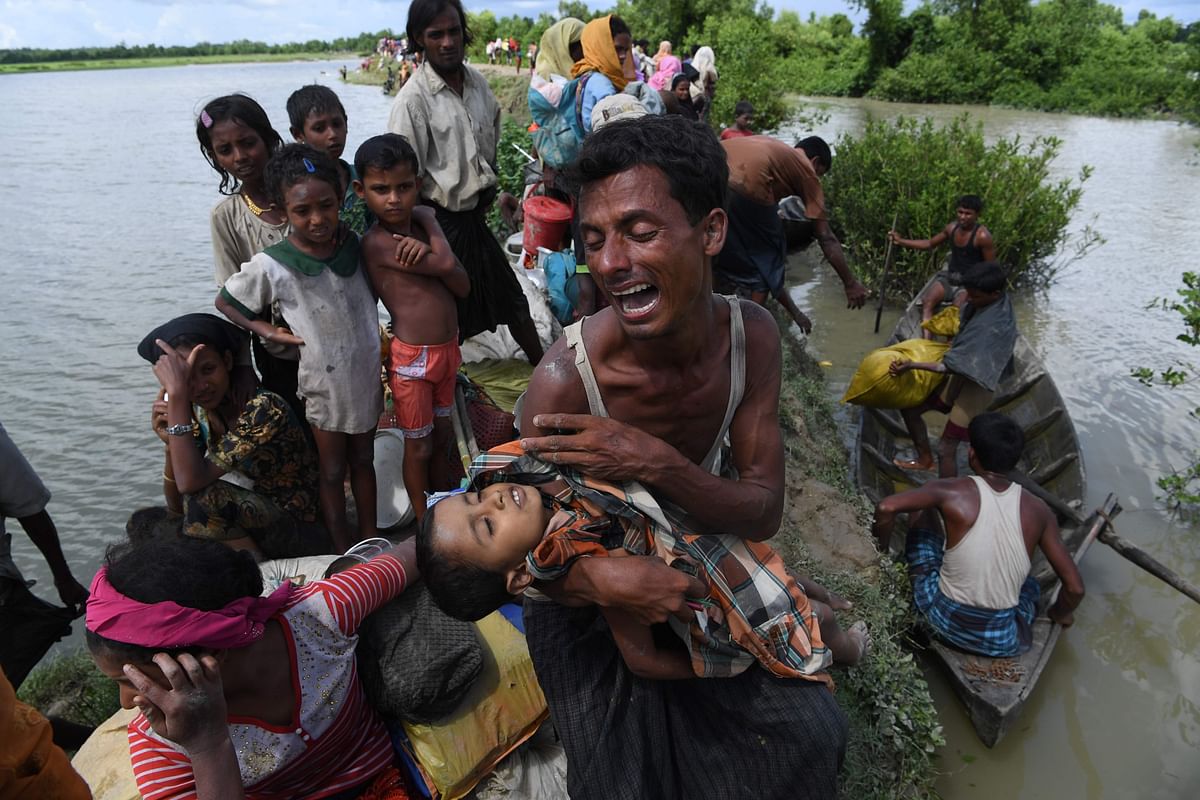 In this file photo taken on 9 October 2017 a Rohingya refugee reacts while holding his dead son after crossing the Naf river from Myanmar into Bangladesh in Whaikhyang. Photo: AFP
