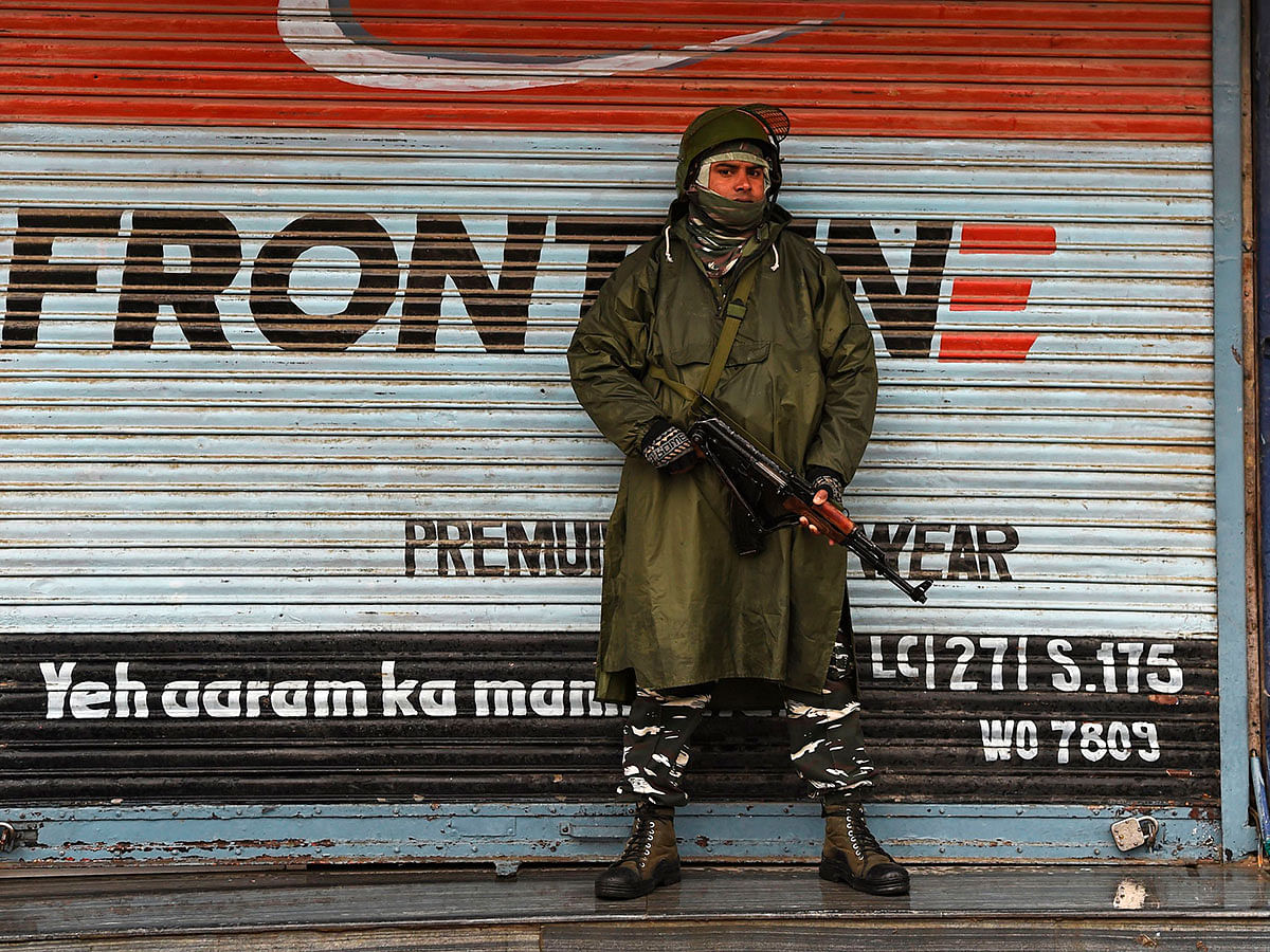 An Indian paramilitary trooper stands guard in front of closed shops during a lockdown in Srinagar on 22 November 2019. Photo: AFP