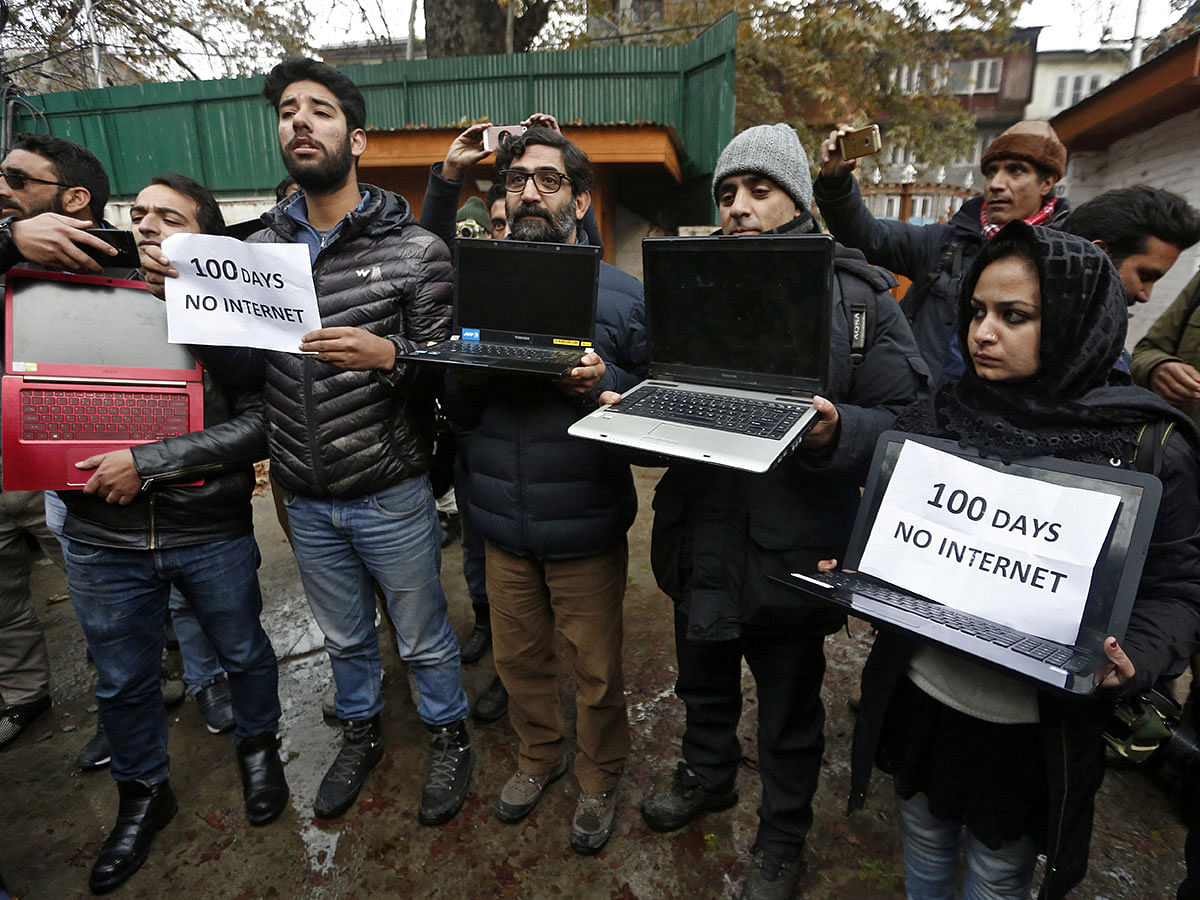 Kashmiri journalists display laptops and placards during a protest demanding restoration of internet service, in Srinagar, on 12 November 2019. Photo: Reuters